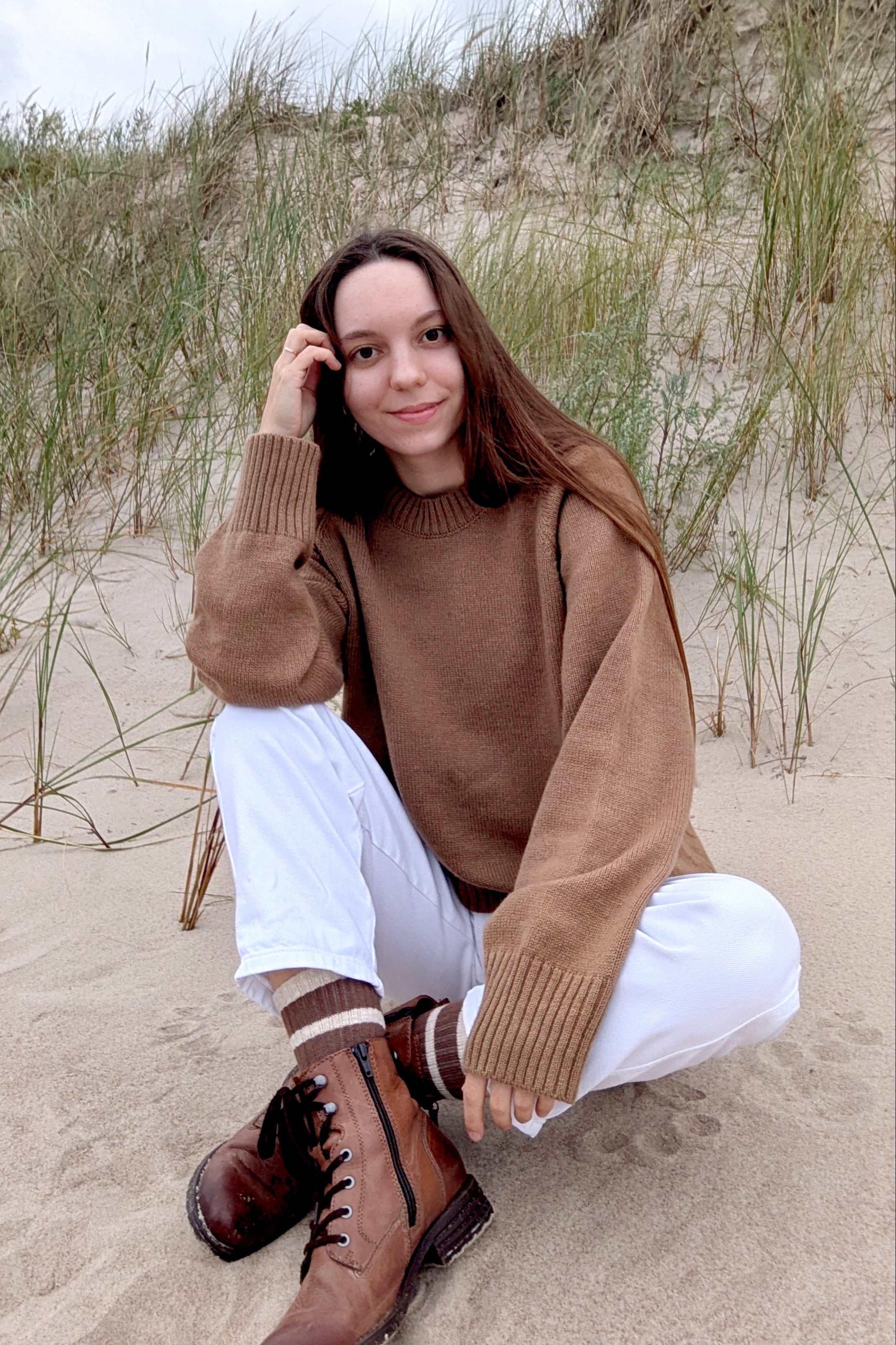 Light cinnamon Woman sitting in brown raglan merino sweater