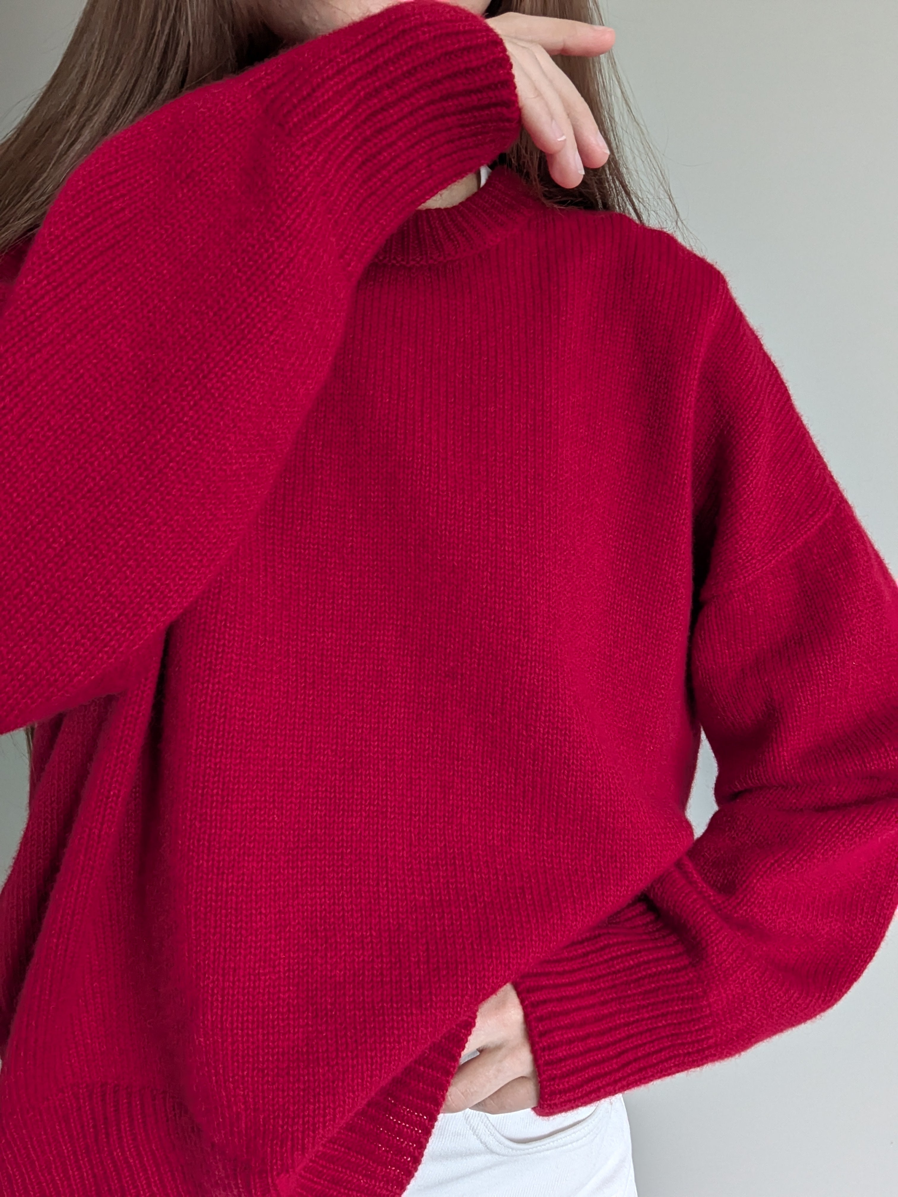 Red sweater worn by a person against a neutral background
