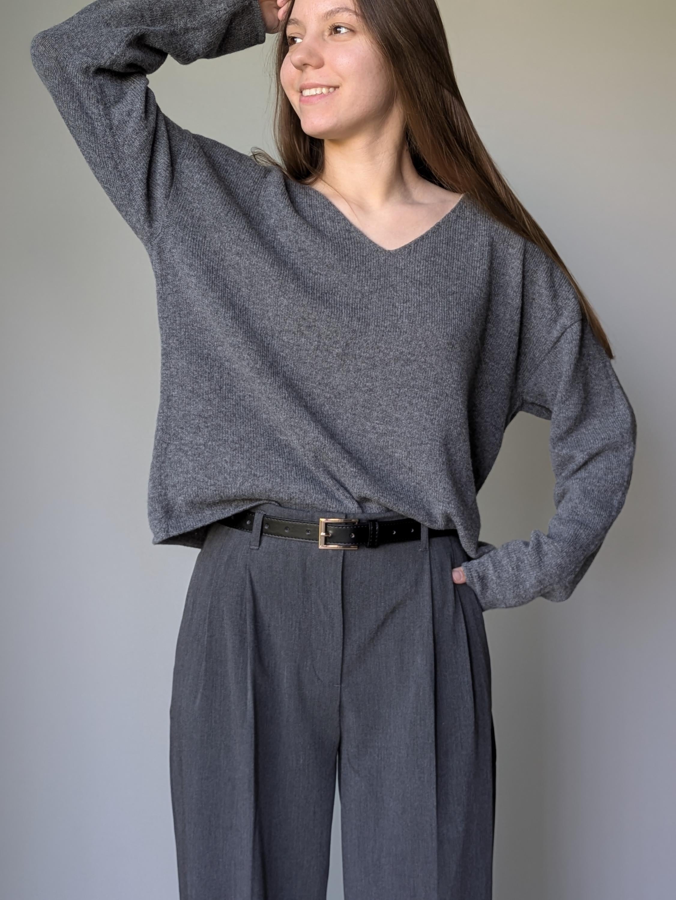 Gray Woman wearing a gray sweater and pants against a plain background
