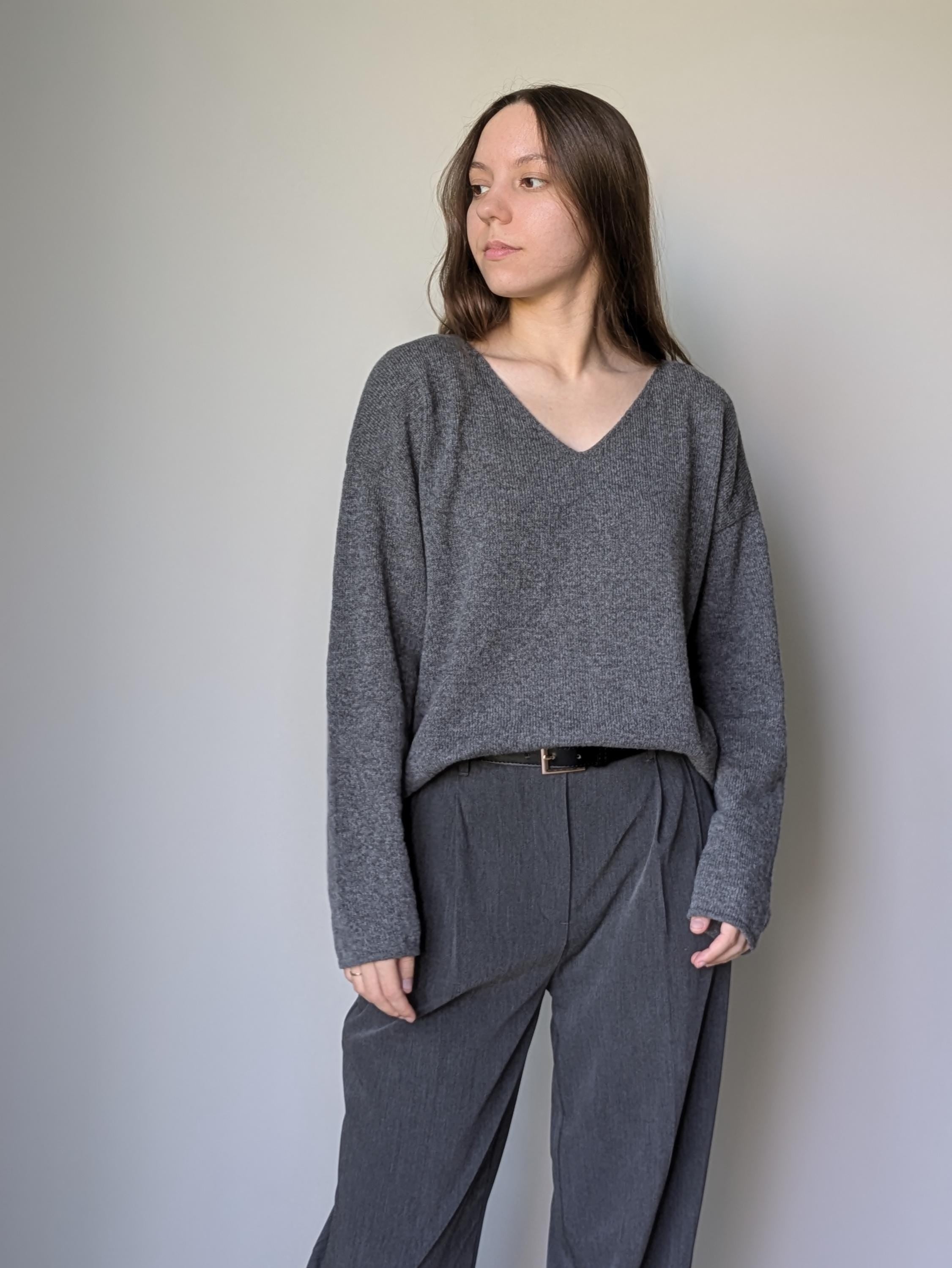 Gray Woman wearing a gray sweater and pants against a plain background