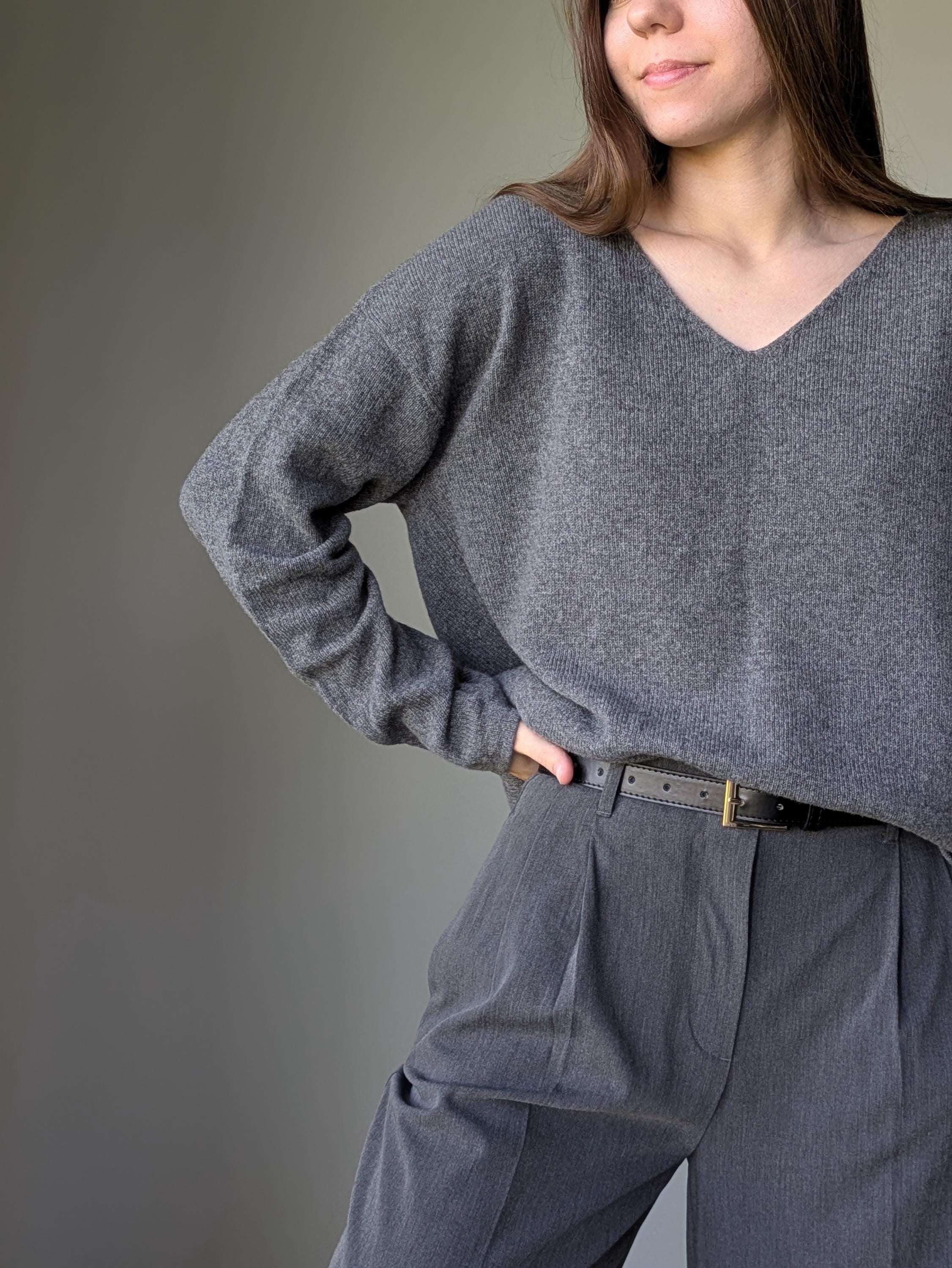 Gray Person wearing a gray sweater and pants against a plain background