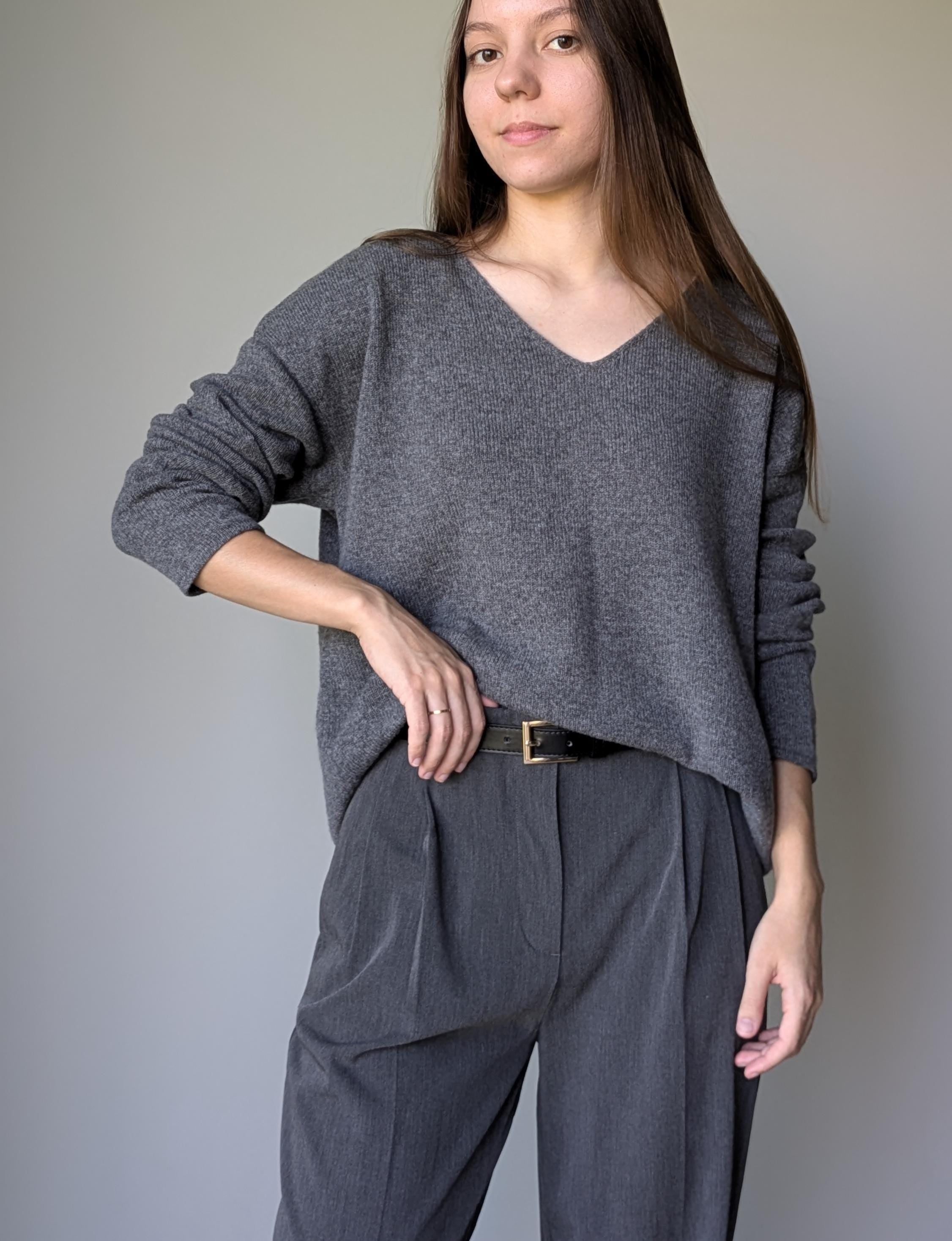 Gray Woman wearing a gray sweater and pants against a plain background