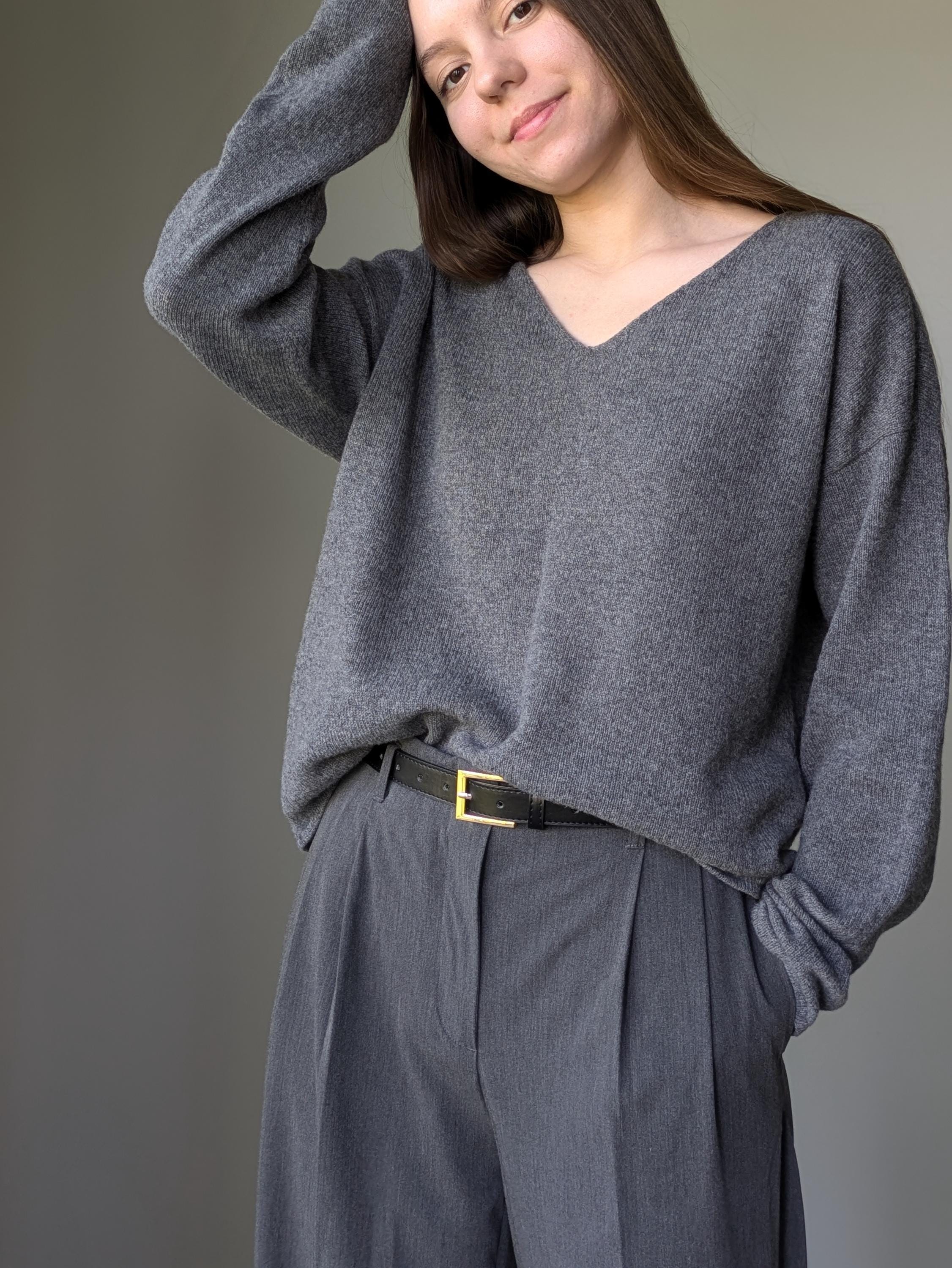 Gray Woman wearing a gray sweater and pants against a plain background
