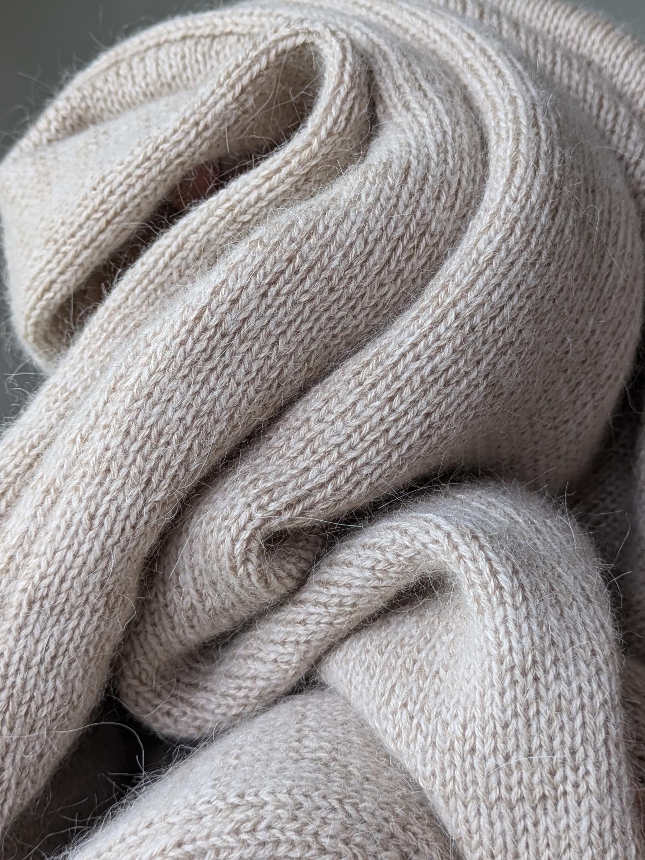 Sand close-up of a knitted beige scarf