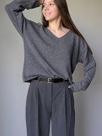 Gray Woman wearing a gray sweater and pants against a plain background