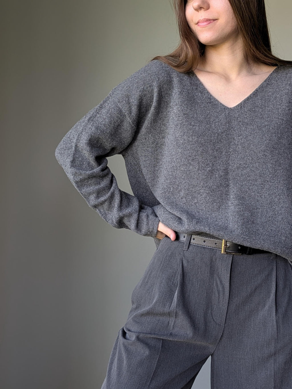 Gray Person wearing a gray sweater and pants against a plain background