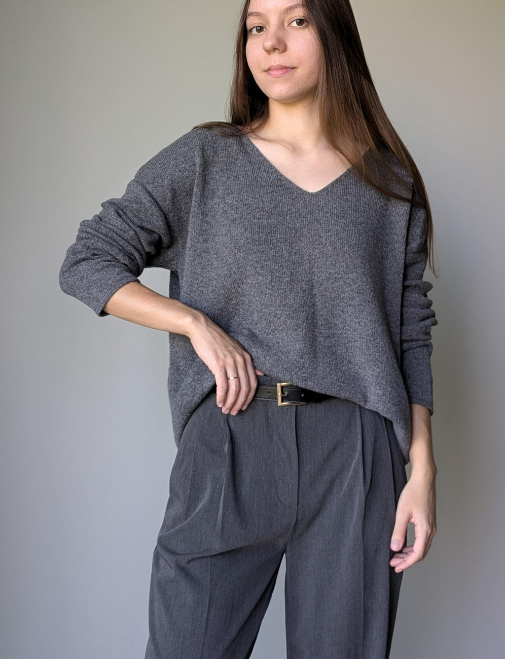 Gray Woman wearing a gray sweater and pants against a plain background