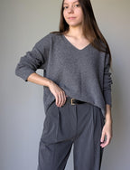 Gray Woman wearing a gray sweater and pants against a plain background