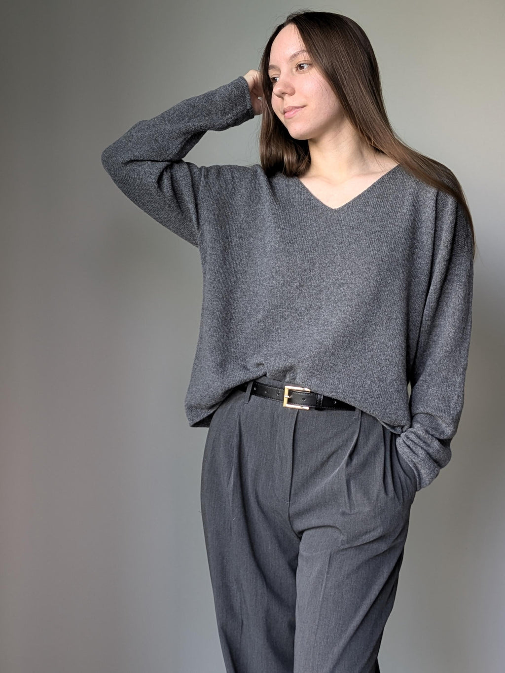 Gray Person wearing a gray sweater and pants against a plain background
