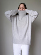 Pearl gray Person wearing a gray sweater with a plain background